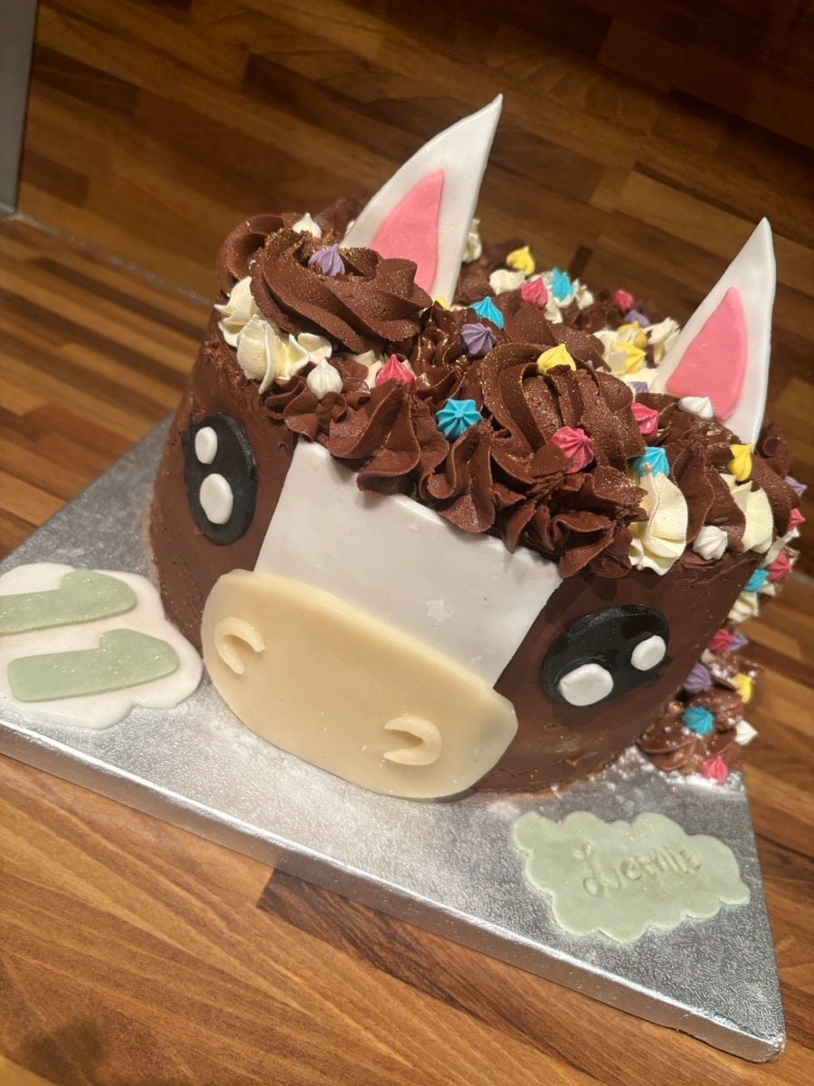 Une tête de poney aux grandes oreilles, au museau clair et à la crinière de pochages chocolat et ivoire.