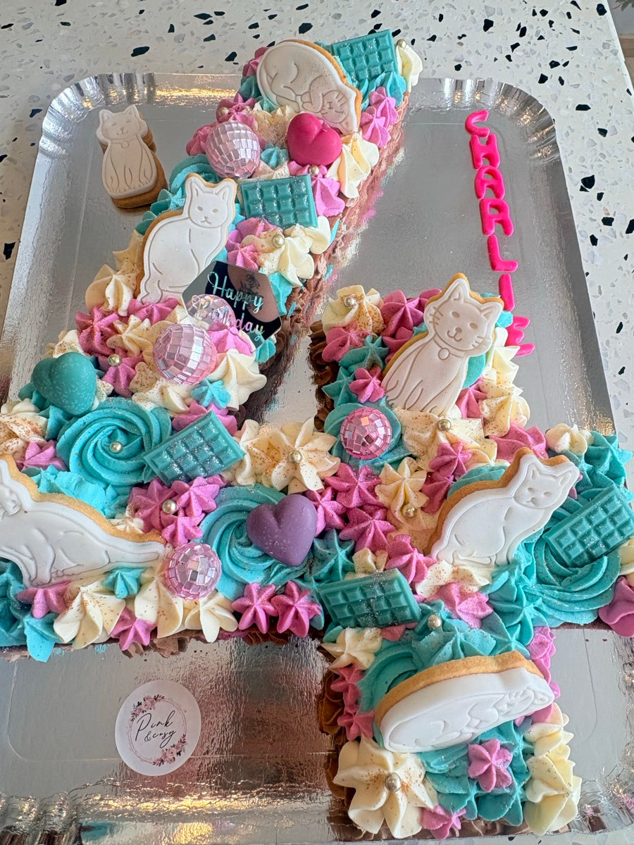 Un chiffre 4 couvert de pochages turquoise, roses et ivoire, avec des petits personnages, des étoiles et des décors multicolores.